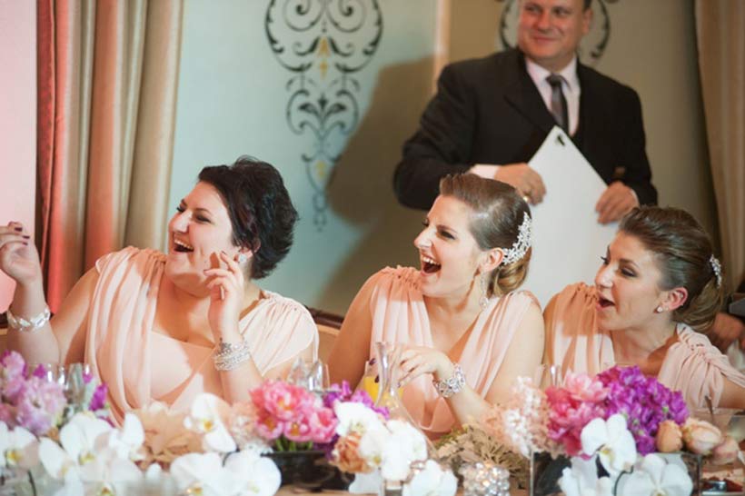 The bridesmaids enjoy a laugh, pink flowers